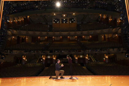 Couple getting engaged on stage at the New Amsterdam Theatre for Disney Aladdin on Broadway engagement package