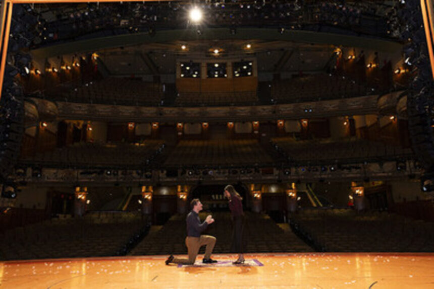 Couple getting engaged on stage at the New Amsterdam Theatre for Disney Aladdin on Broadway engagement package