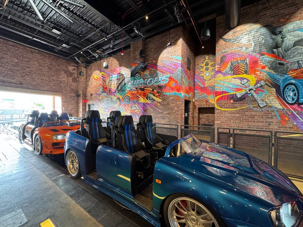 Full coaster train on the ride platform inside Fast & Furious: Hollywood Drift station at Universal Studios Hollywood with Tristan Eaton mural