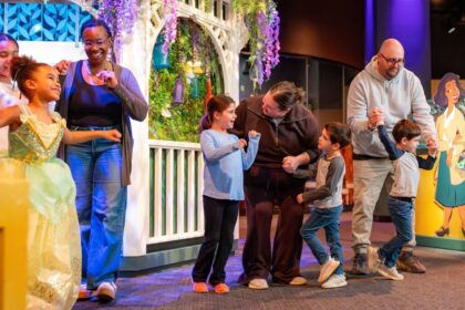 Families dancing and celebrating at Tianas Joyful Celebration exhibit at The Childrens Museum of Indianapolis