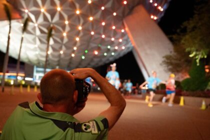 Disney PhotoPass cast member Dave Devore photographs runners during a runDisney race weekend at Walt Disney World