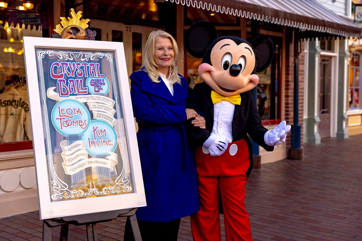 Kim Irvine with Mickey Mouse and framed window artwork for the Kim Irvine and Leota Toombs Main Street U.S.A. window