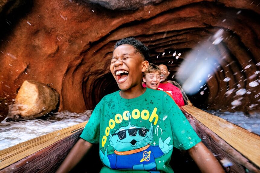 Children laugh while riding a Disneyland Resort water attraction during summer