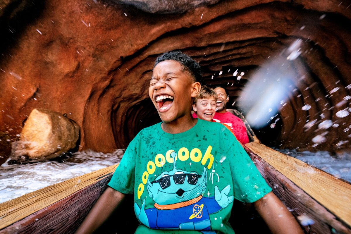 Children laugh while riding a Disneyland Resort water attraction during summer