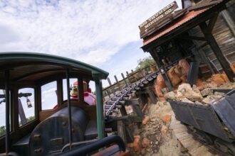 A Big Thunder Mountain Railroad train near the Big Thunder Mining Co. building at Magic Kingdom