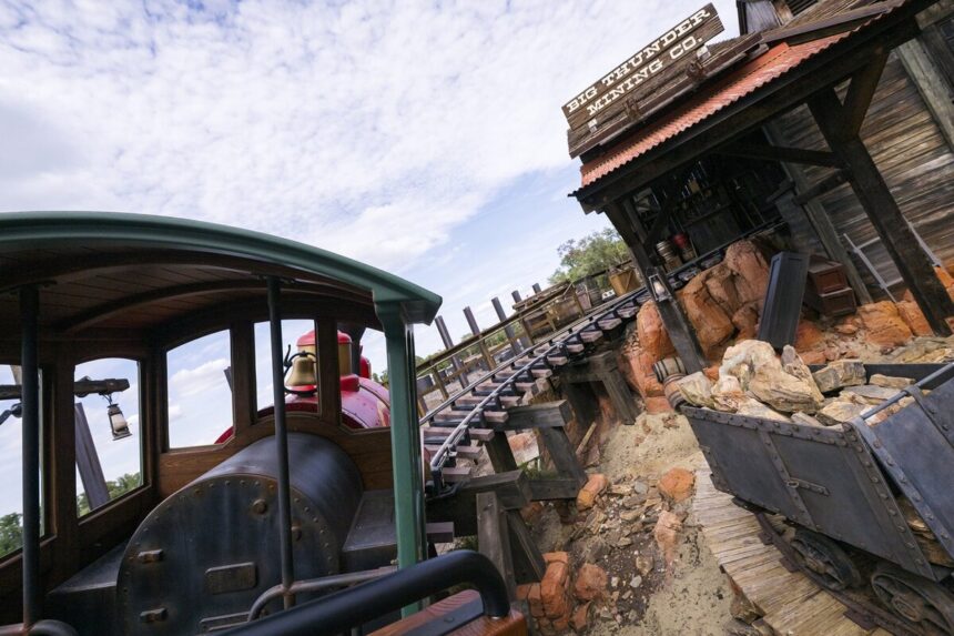 A Big Thunder Mountain Railroad train near the Big Thunder Mining Co. building at Magic Kingdom