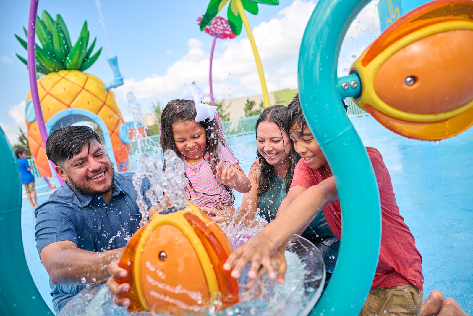 Family playing at a jellyfish water feature in the SpongeBob Bikini Bottom land at Universal Kids Resort