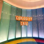 Bright Curiosity Cafe signage wall at Universal Kids Resort in Frisco, Texas