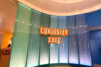Bright Curiosity Cafe signage wall at Universal Kids Resort in Frisco, Texas