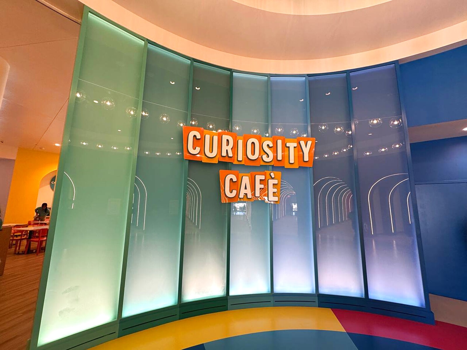 Bright Curiosity Cafe signage wall at Universal Kids Resort in Frisco, Texas