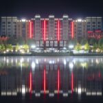 Disney Hotel New York – The Art of Marvel at Disneyland Paris lit at night, reflected in Lake Disney