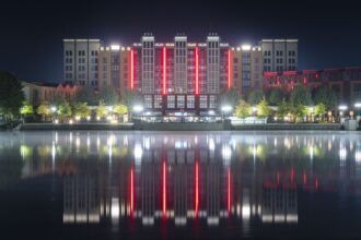 Disney Hotel New York – The Art of Marvel at Disneyland Paris lit at night, reflected in Lake Disney