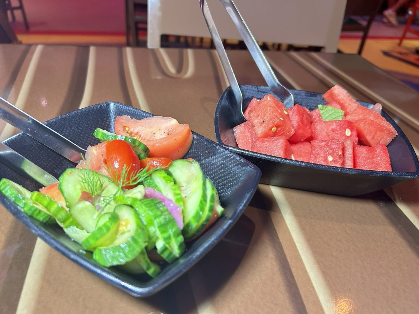 Cucumber-tomato salad and fresh watermelon starters at Roundup Rodeo BBQ