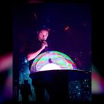 A performer creates a giant illuminated bubble during the Gazillion Bubble Show at Carowinds