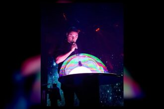 A performer creates a giant illuminated bubble during the Gazillion Bubble Show at Carowinds