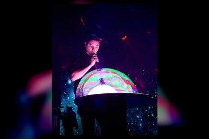 A performer creates a giant illuminated bubble during the Gazillion Bubble Show at Carowinds