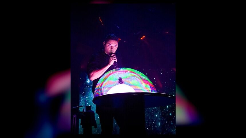 A performer creates a giant illuminated bubble during the Gazillion Bubble Show at Carowinds