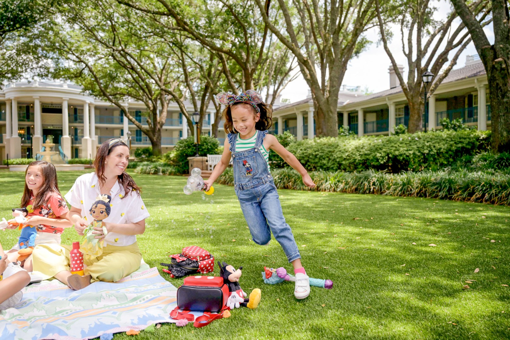 Family playing with bubbles on a resort lawn at Disney's Port Orleans Resort Riverside