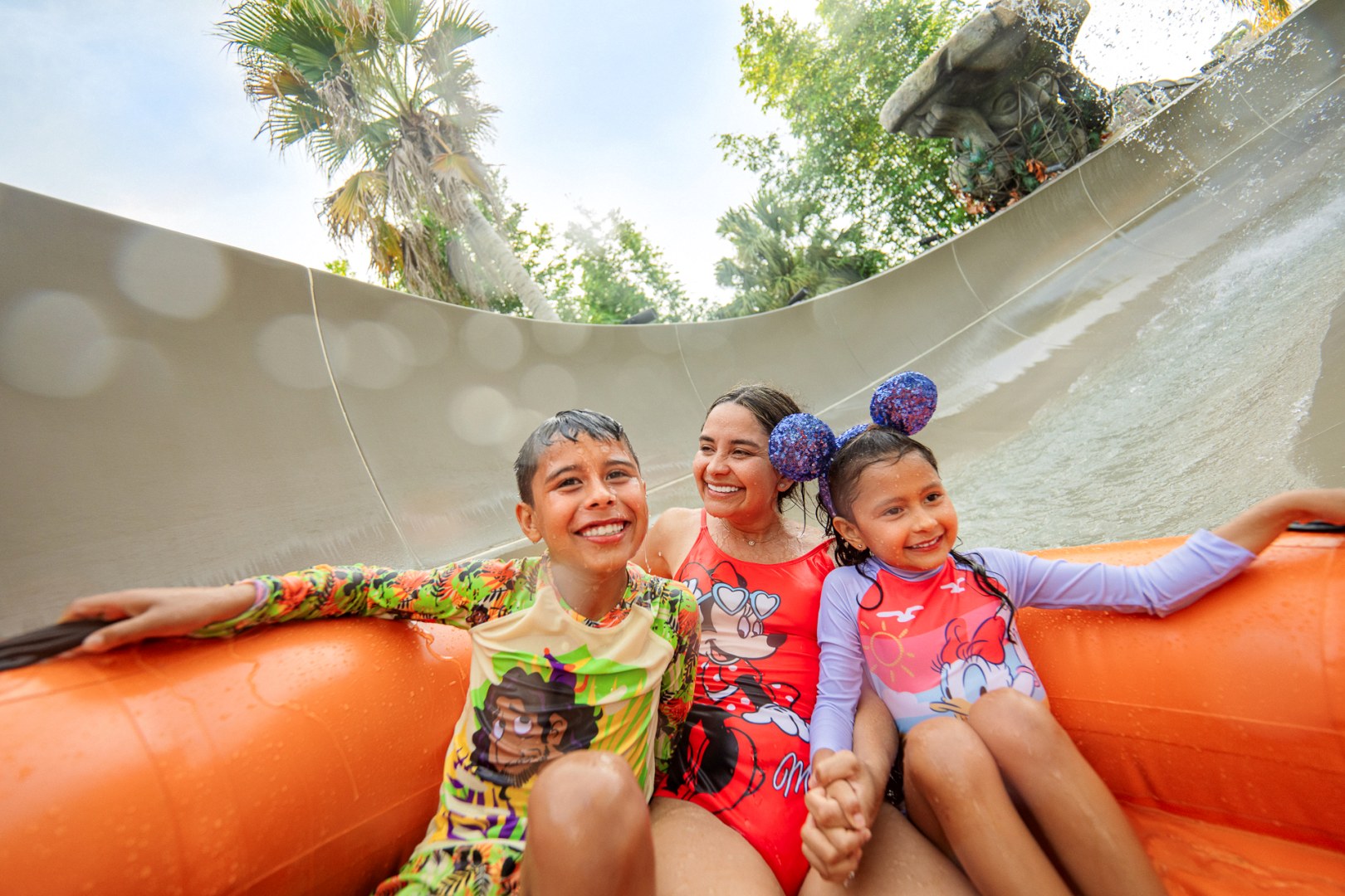 Family riding a water slide raft at a Walt Disney World water park