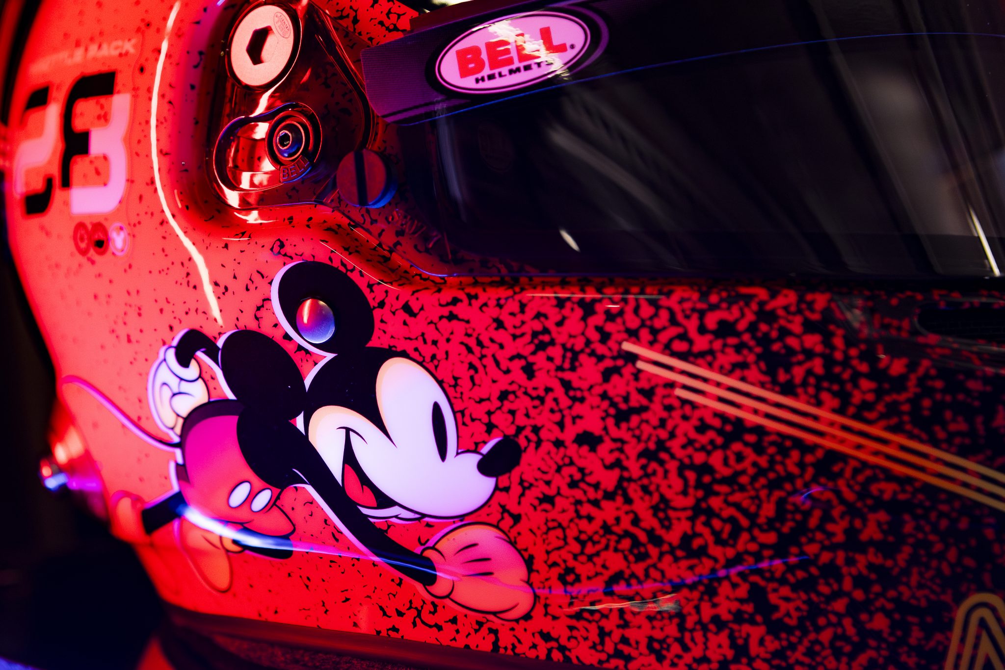 Close-up of Mickey Mouse artwork on the red and black Disney Formula 1 racing helmet