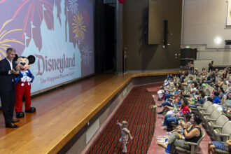 Josh D'Amaro and Mickey Mouse surprise Camp Pendleton military families with Disneyland Resort tickets during a Toy Story 5 screening.