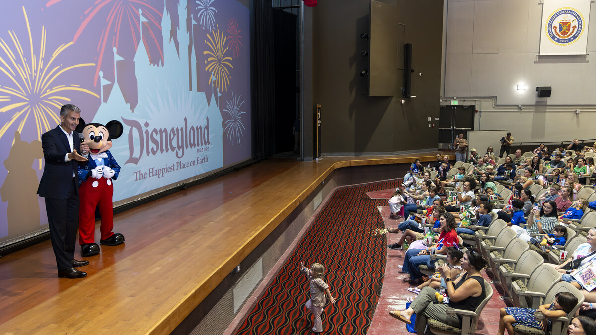Josh D'Amaro and Mickey Mouse surprise Camp Pendleton military families with Disneyland Resort tickets during a Toy Story 5 screening.