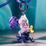 A Magic Key straw clip with an Ursula figure holding a scroll