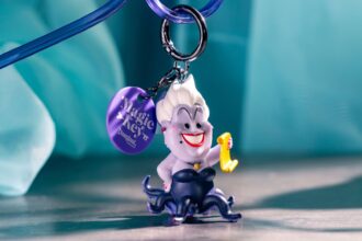 A Magic Key straw clip with an Ursula figure holding a scroll