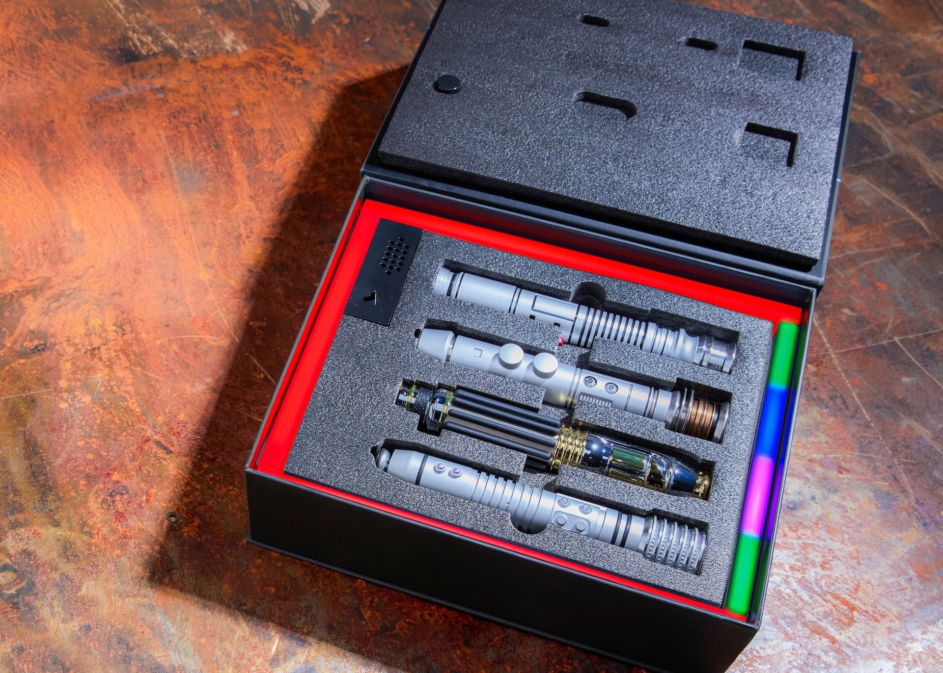 The Legacy Lightsaber Box Set open and lit, showing all four Jedi hilts