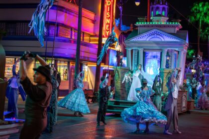 Performers in blue period costumes dance at Madame Leota's Swinging Wake at Disney California Adventure Park