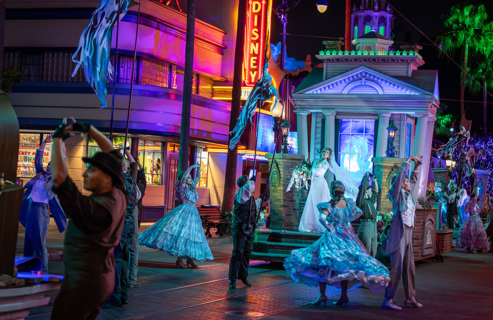 Performers in blue period costumes dance at Madame Leota's Swinging Wake at Disney California Adventure Park