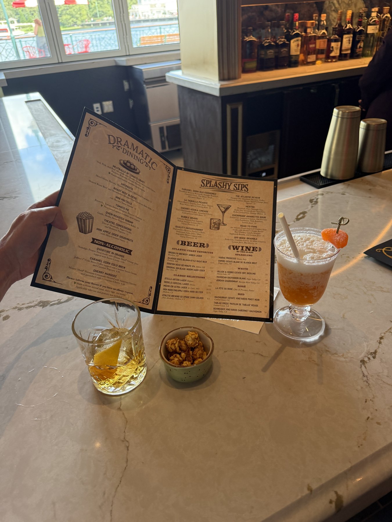 An open Hurly-Burly menu showing Dramatic Dining, Non-Alcoholic, Splashy Sips, beer and wine selections.