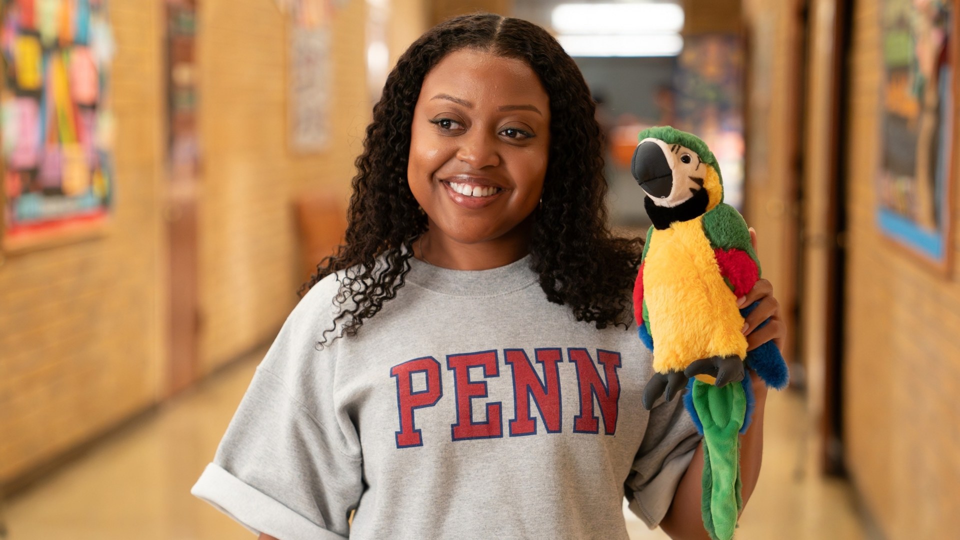 Janine Teagues, played by Quinta Brunson, wears a Penn shirt and holds a parrot plushie in a scene from Season 6 of Abbott