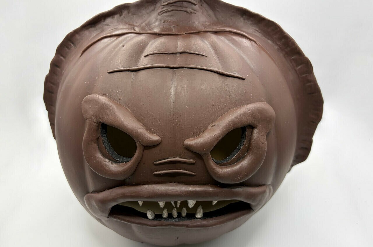 Roll the modeling clay into very thin worms and press them to the face as wrinkles.